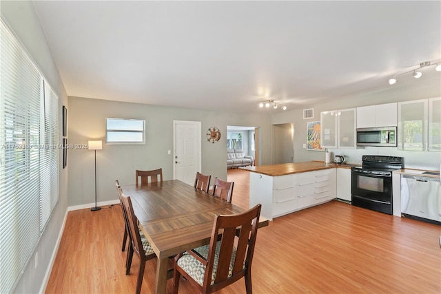 dining area with visible vents and light wood-style flooring