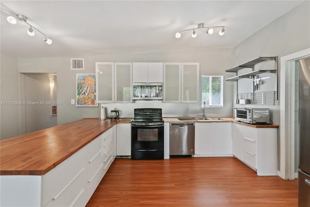 kitchen with visible vents, a peninsula, a toaster, a sink, and stainless steel appliances
