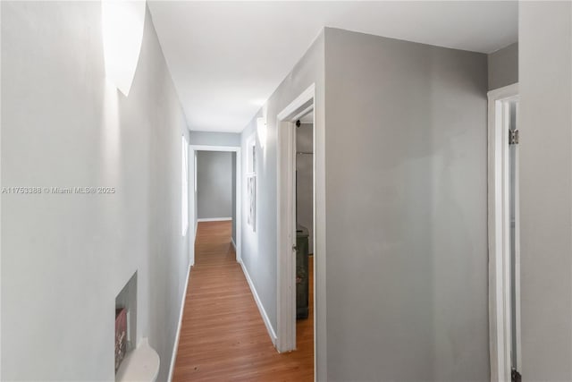 hallway featuring baseboards and light wood finished floors