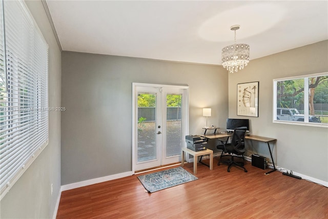 office area featuring baseboards, an inviting chandelier, a healthy amount of sunlight, and wood finished floors