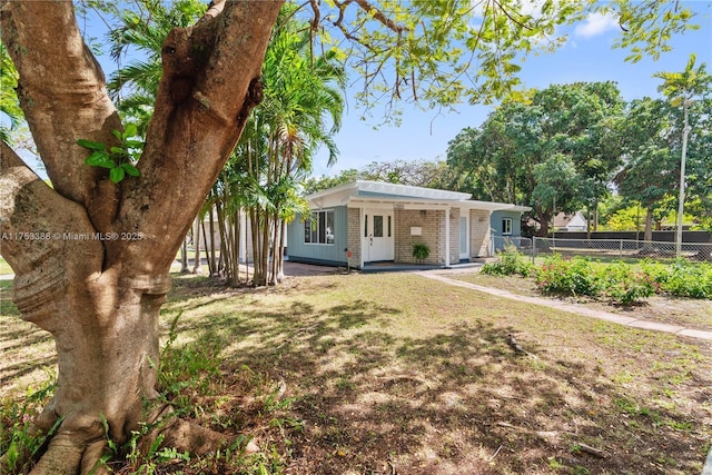 view of front of property with fence, a carport, and brick siding