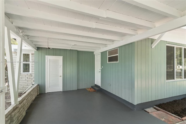 view of exterior entry featuring a patio and an attached carport