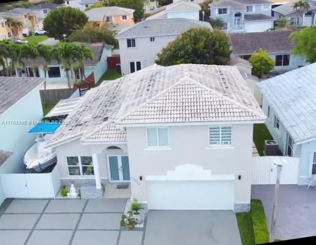 exterior space with driveway, french doors, a residential view, and a tiled roof