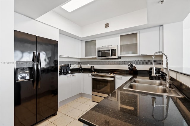 kitchen featuring white cabinets, visible vents, light tile patterned floors, a sink, and appliances with stainless steel finishes