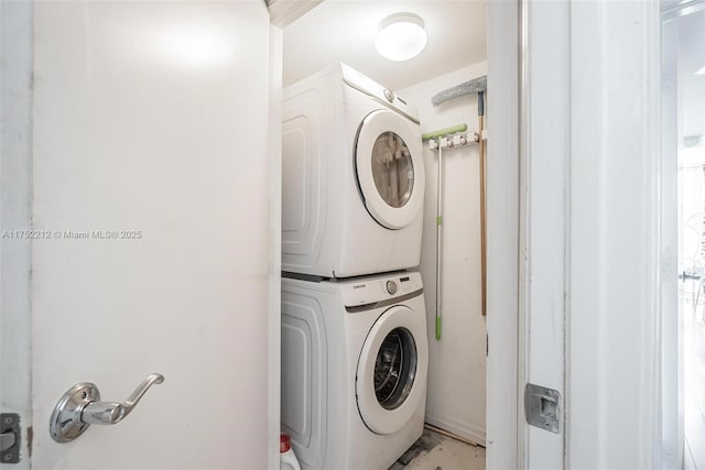 clothes washing area featuring stacked washer / drying machine and laundry area