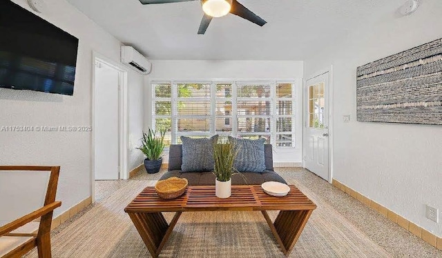 sitting room featuring ceiling fan, baseboards, and a wall mounted air conditioner