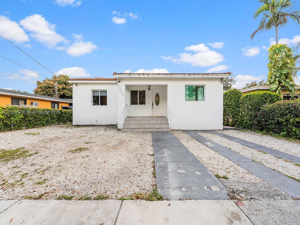 1230 NW 35th St, Miami, FL 33142 - bungalow-style house with fence, stucco siding, and a tiled roof