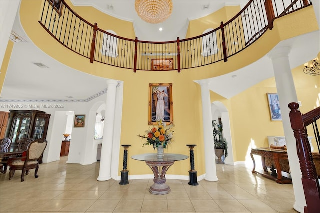 interior space featuring arched walkways, baseboards, and ornate columns