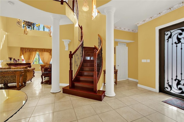 entryway featuring light tile patterned floors, ornate columns, stairway, ornamental molding, and baseboards