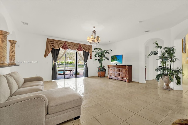 living room with a chandelier, arched walkways, visible vents, and light tile patterned floors