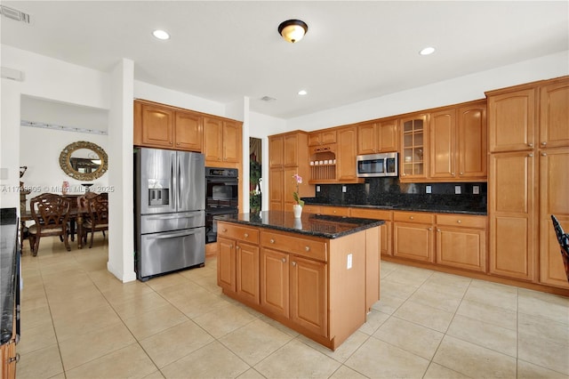 kitchen featuring a center island, visible vents, decorative backsplash, dark stone counters, and black appliances