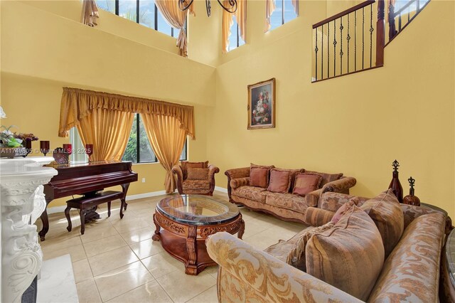 living area featuring a high ceiling, baseboards, and light tile patterned floors