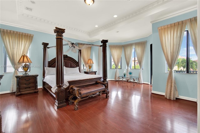 bedroom featuring a raised ceiling, visible vents, crown molding, and hardwood / wood-style floors