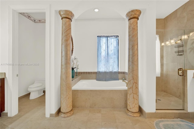 bathroom with a stall shower, a garden tub, toilet, and ornate columns