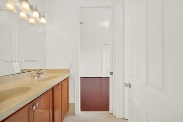 full bath with double vanity, a sink, and tile patterned floors