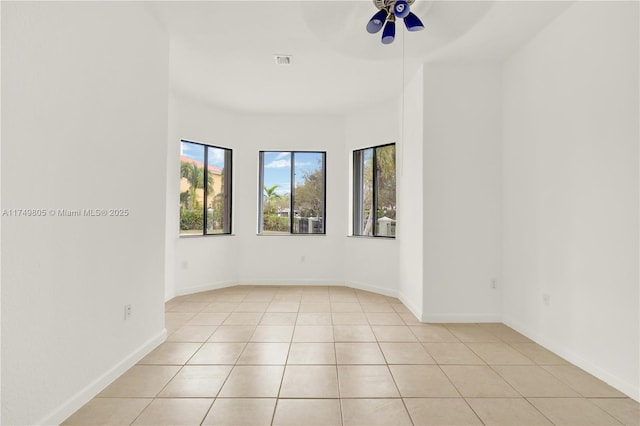 unfurnished room featuring light tile patterned floors, baseboards, visible vents, and ceiling fan