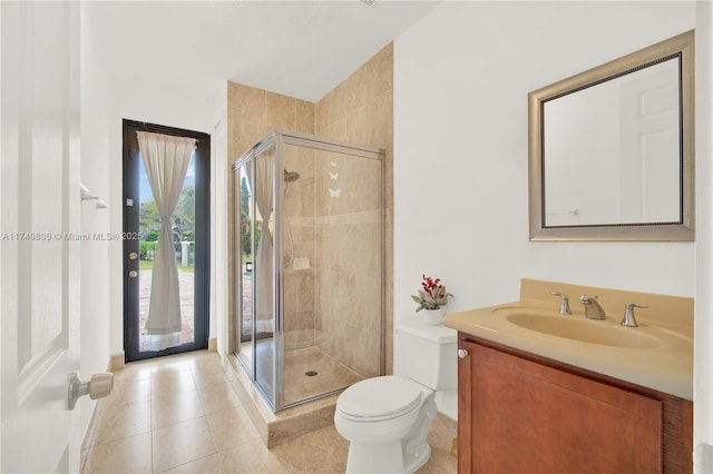 bathroom featuring toilet, a shower stall, vanity, and tile patterned floors