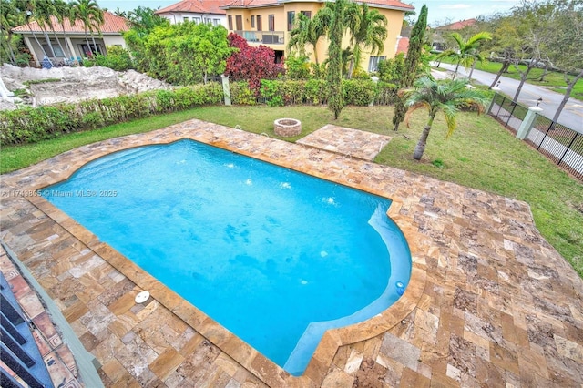 view of swimming pool featuring a fenced in pool, a patio, a lawn, an outdoor fire pit, and a fenced backyard