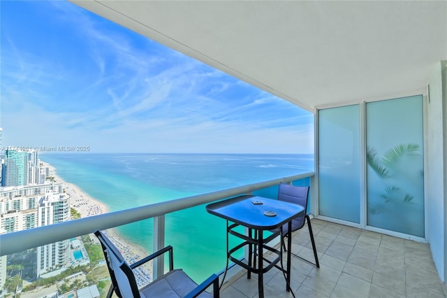 balcony featuring a beach view, a water view, and a city view