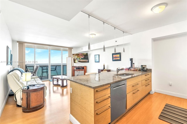 kitchen featuring open floor plan, stone counters, light wood-style floors, floor to ceiling windows, and stainless steel dishwasher