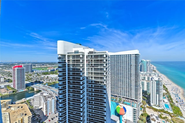 view of property featuring a view of the beach, a water view, and a city view