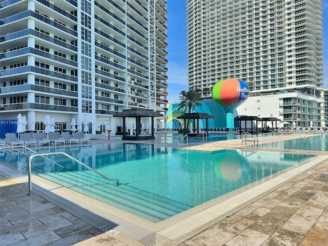 community pool with a view of city and a gazebo