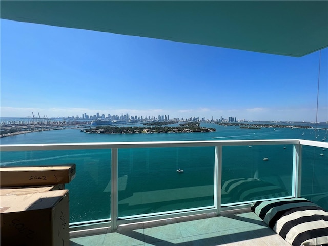 balcony featuring a water view and a city view