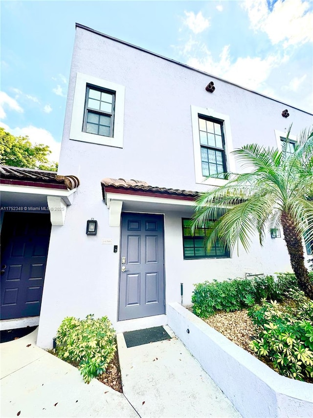 view of front of property featuring a tiled roof and stucco siding