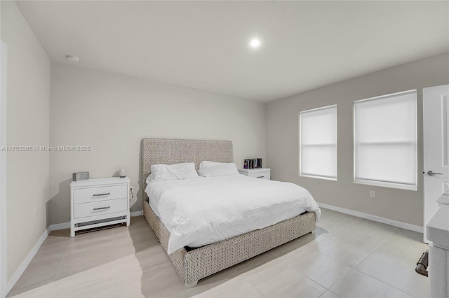 bedroom with baseboards and light tile patterned floors