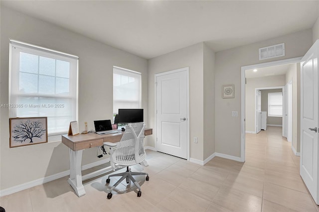 home office with light tile patterned floors, visible vents, and baseboards