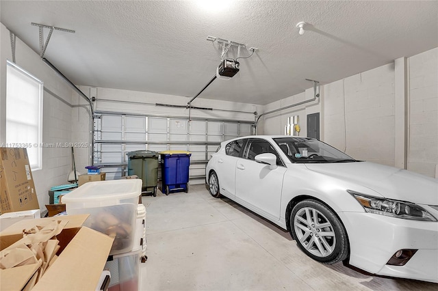 garage with concrete block wall, electric panel, and a garage door opener