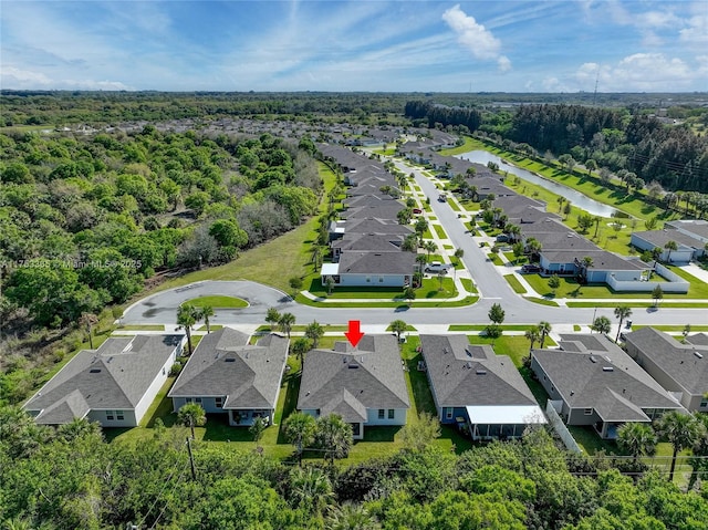 bird's eye view featuring a water view, a wooded view, and a residential view