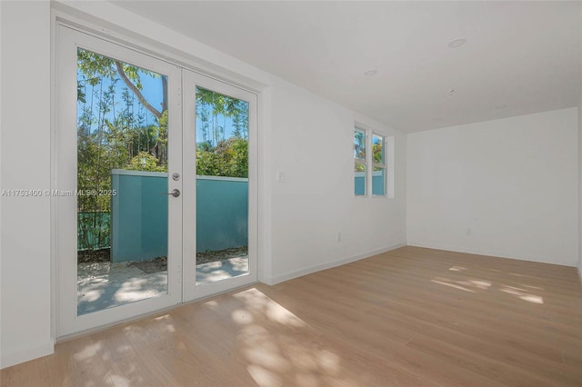 unfurnished room featuring french doors, wood finished floors, and baseboards