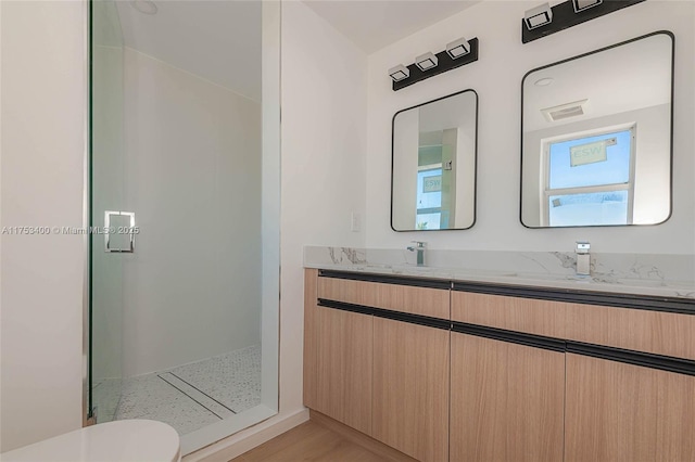 bathroom featuring double vanity and walk in shower