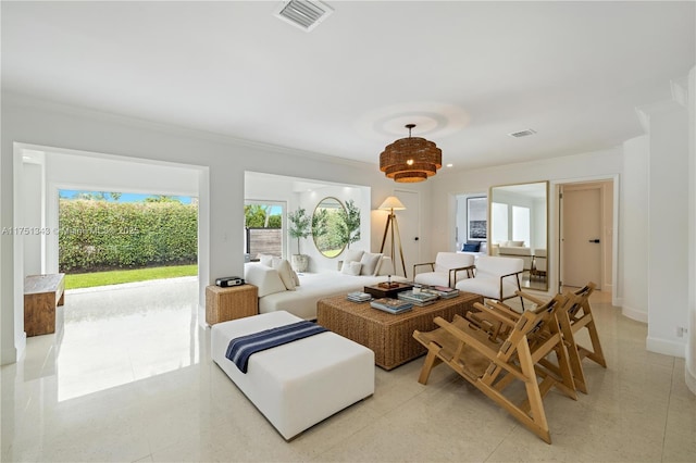 living room featuring baseboards, visible vents, and crown molding