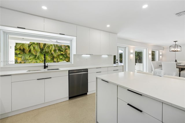 kitchen with dishwasher, light countertops, a sink, and recessed lighting