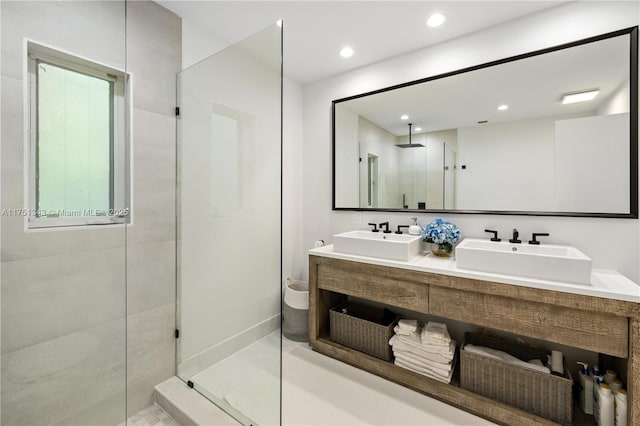 full bathroom featuring double vanity, recessed lighting, a sink, and a shower stall