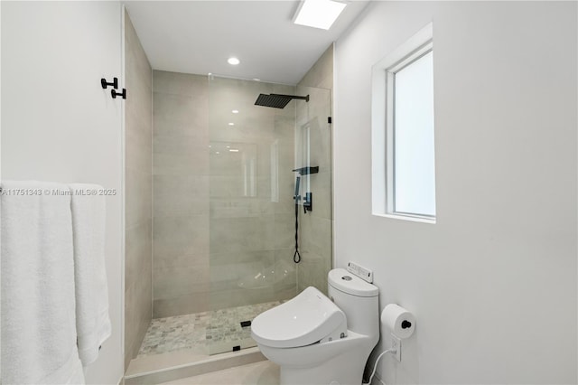 bathroom featuring a tile shower and toilet