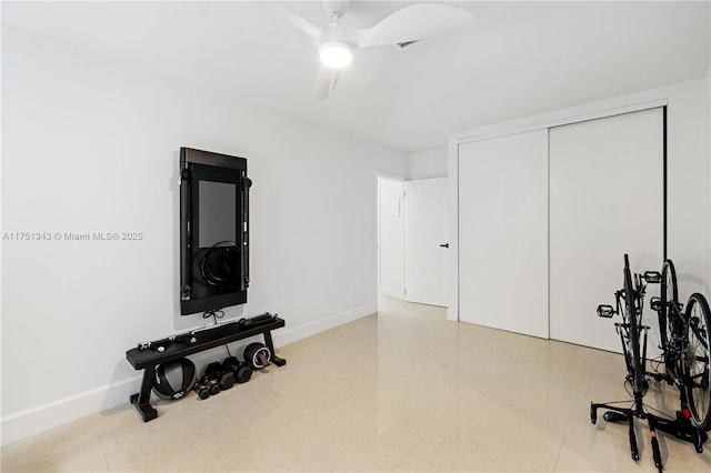 workout room featuring baseboards and a ceiling fan