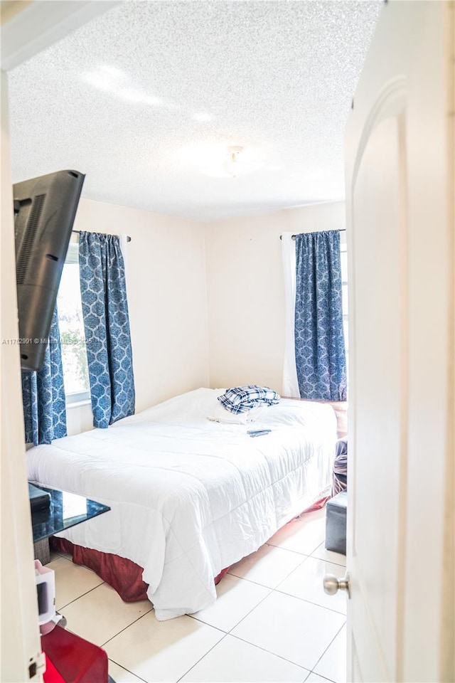 tiled bedroom with a textured ceiling