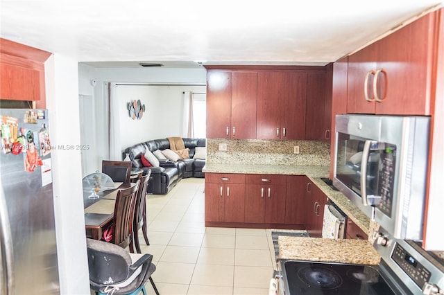 kitchen with light stone counters, visible vents, appliances with stainless steel finishes, open floor plan, and light tile patterned flooring