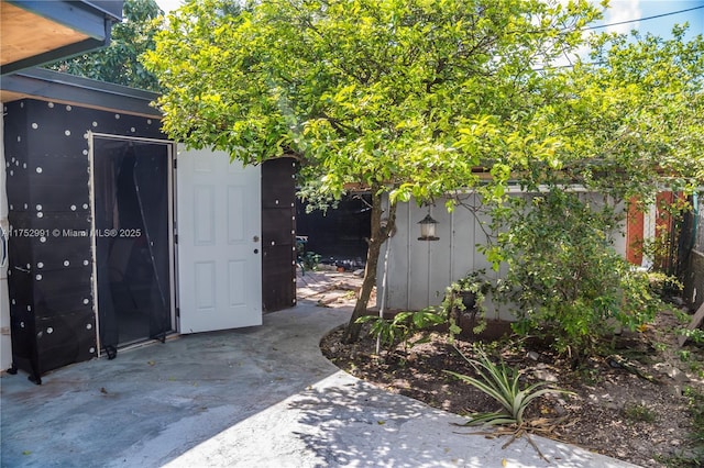 view of outbuilding featuring fence and an outdoor structure