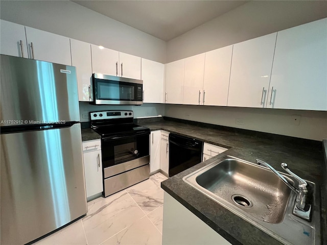 kitchen featuring marble finish floor, appliances with stainless steel finishes, dark countertops, and a sink