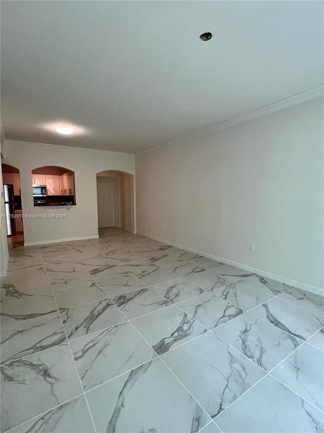 unfurnished living room featuring arched walkways, marble finish floor, ornamental molding, and baseboards