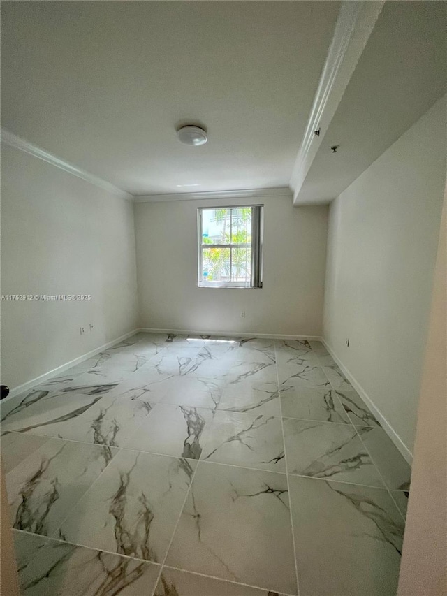 spare room with baseboards, marble finish floor, and crown molding