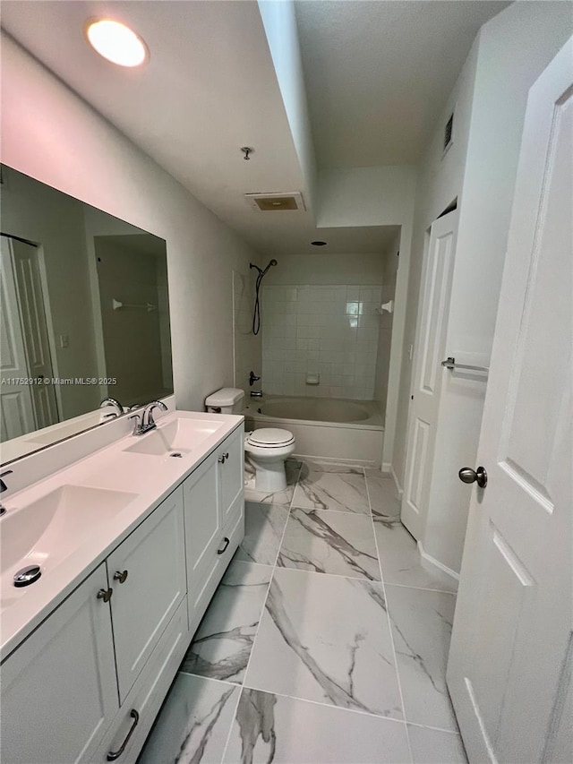 full bathroom featuring toilet, marble finish floor, tub / shower combination, and a sink