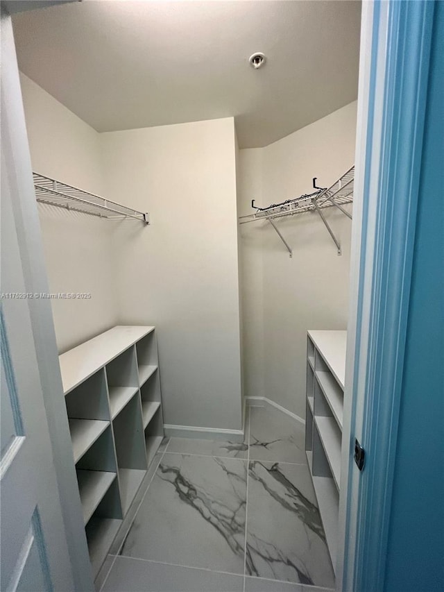 spacious closet with marble finish floor