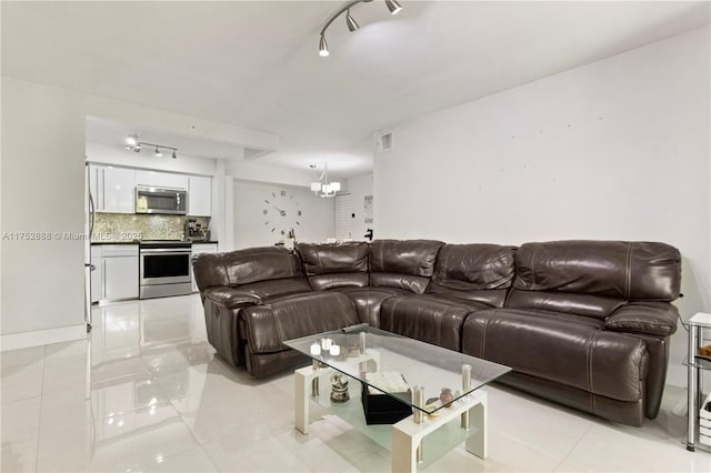 living area featuring light tile patterned floors, track lighting, visible vents, and a notable chandelier