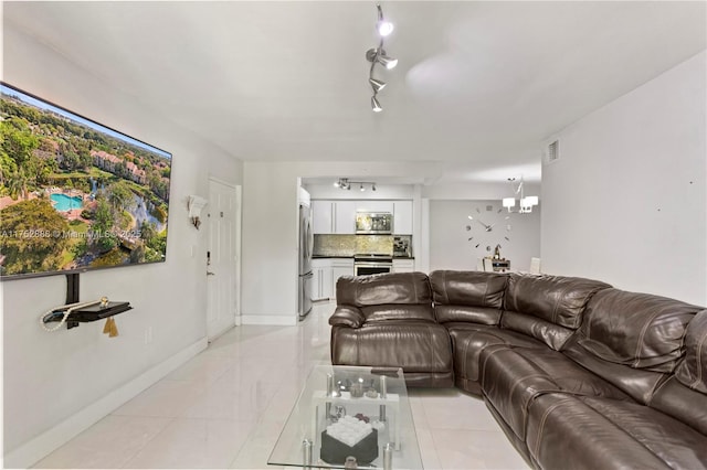 living area with baseboards, visible vents, a chandelier, and track lighting