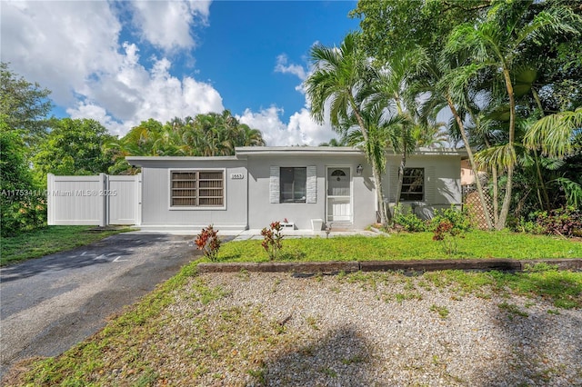 view of front of property with a gate, stucco siding, driveway, and fence